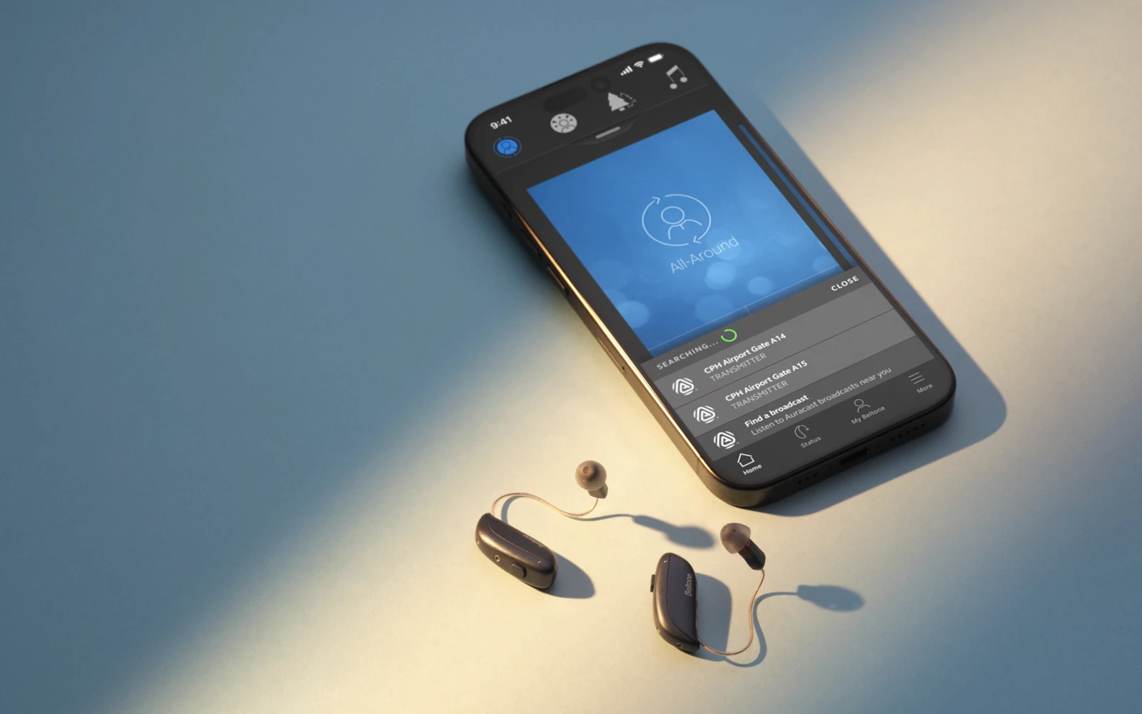 Smartphone mit Hörgeräte-App und modernen Hörgeräten auf blauem Untergrund.